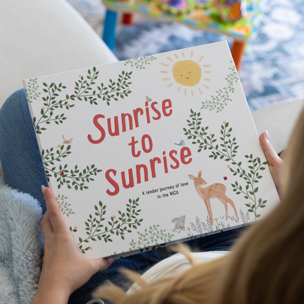Sunrise to Sunrise NICU baby memory book cover with botanical design, smiling sun, and deer illustration